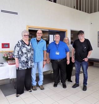 A picture of Paul Avery in the Trans-Oversees Lobby. To his left is Bill Tallman, and Noreen Danca from Cargo Placement Services. To his right is Linda Redding in the background and another gentleman to the far right.